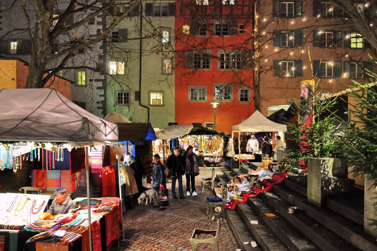 Christmas market stalls on the Rosenhof in the Niederdorf at dusk with lit Old Town houses