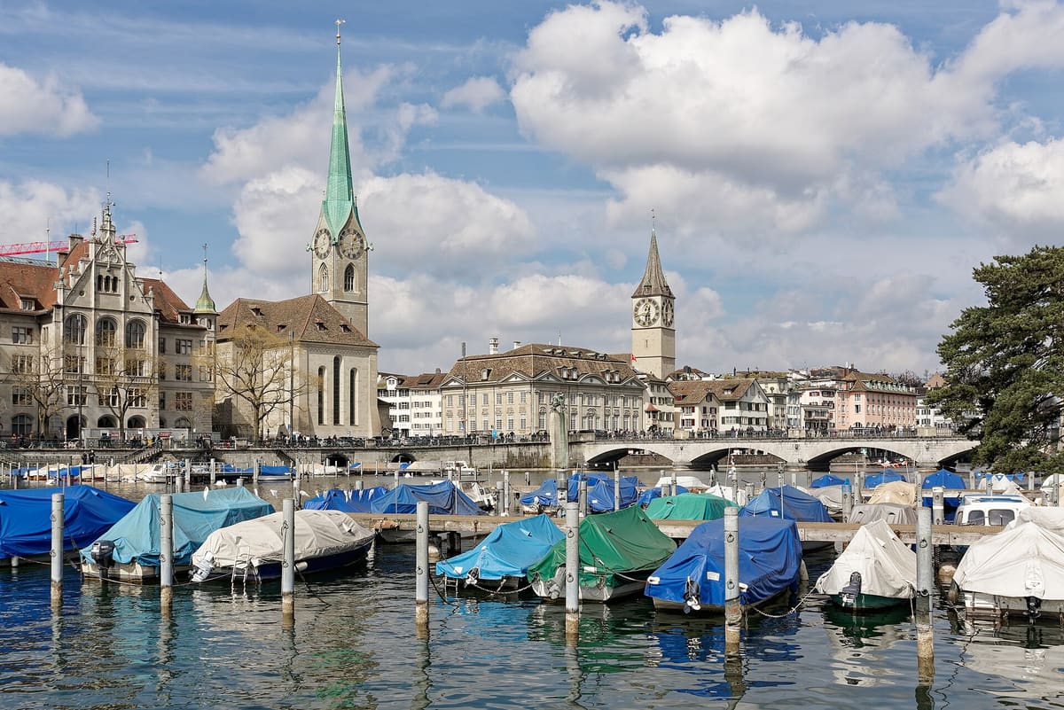 Fraumünster with its green spire, the Münsterbrücke and the clock tower of St. Peter in Zurich
