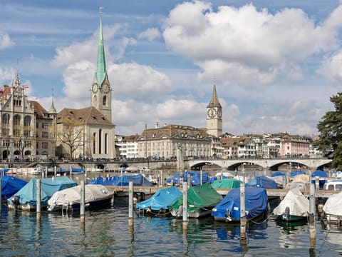 Fraumünster with its green spire, the Münsterbrücke and the clock tower of St. Peter in Zurich