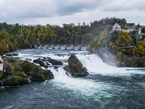 The Rhine Falls in autumn with the middle rock and Schloss Laufen above the falls