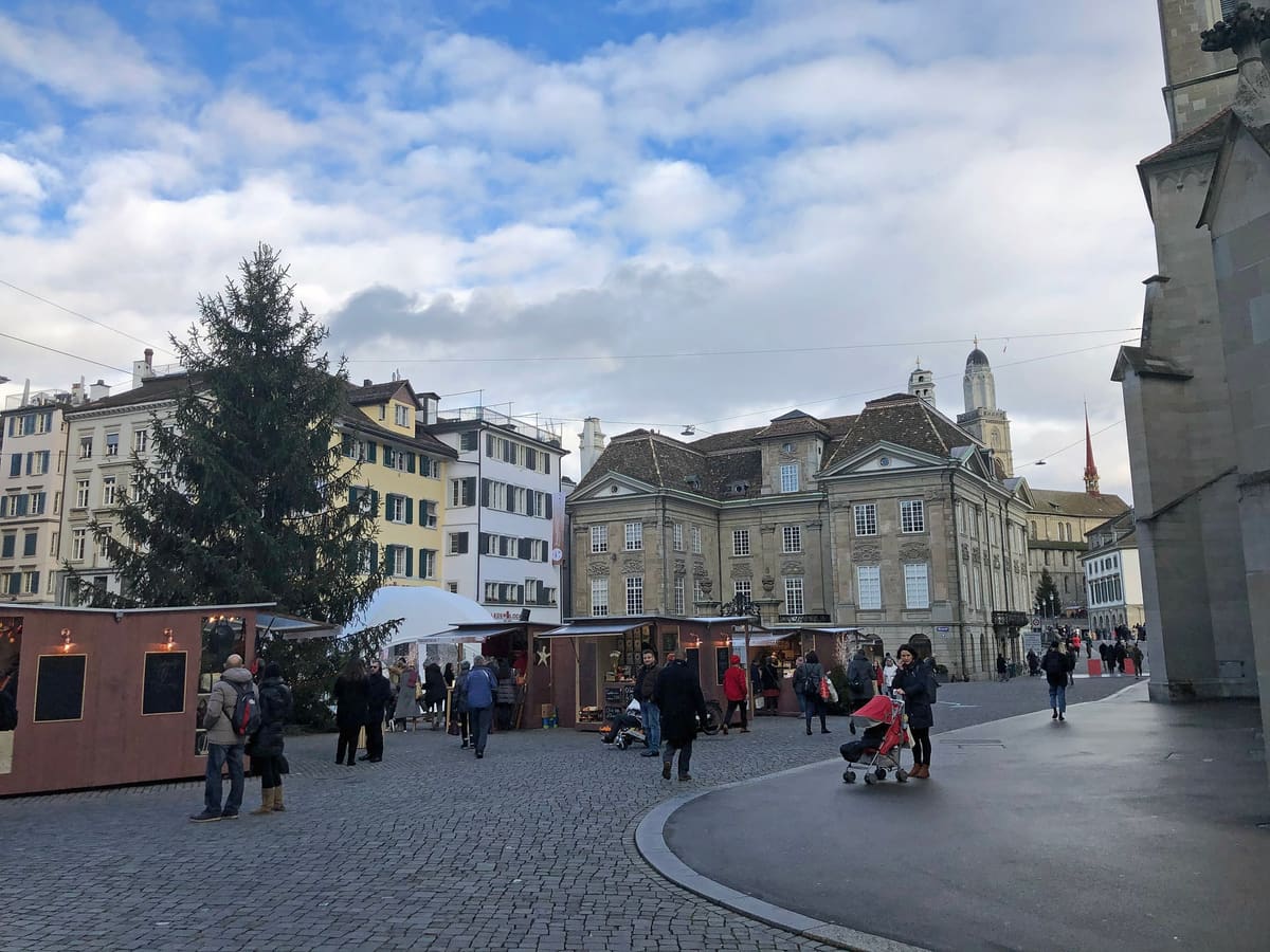 Christmas market huts and a tall Christmas tree on the Münsterhof square in Zurich